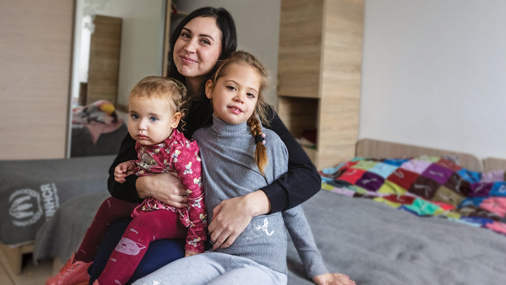 Olga with daughters Taisya and Arina, who received comforters from Mennonite Central Committee, at a shelter near Uzhhorod, Ukraine, in December. — Emily Loewen/MCC