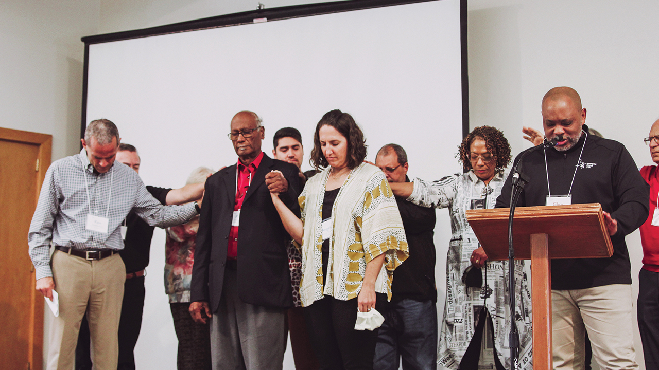 Mosaic Mennonite Conference assistant moderator Roy Williams, center left, and moderator Angela Moyer Walter, center right, pray during the conference assembly Nov. 5 at Souderton, Pa. — Cindy Angela/Mosaic Mennonite Conference
