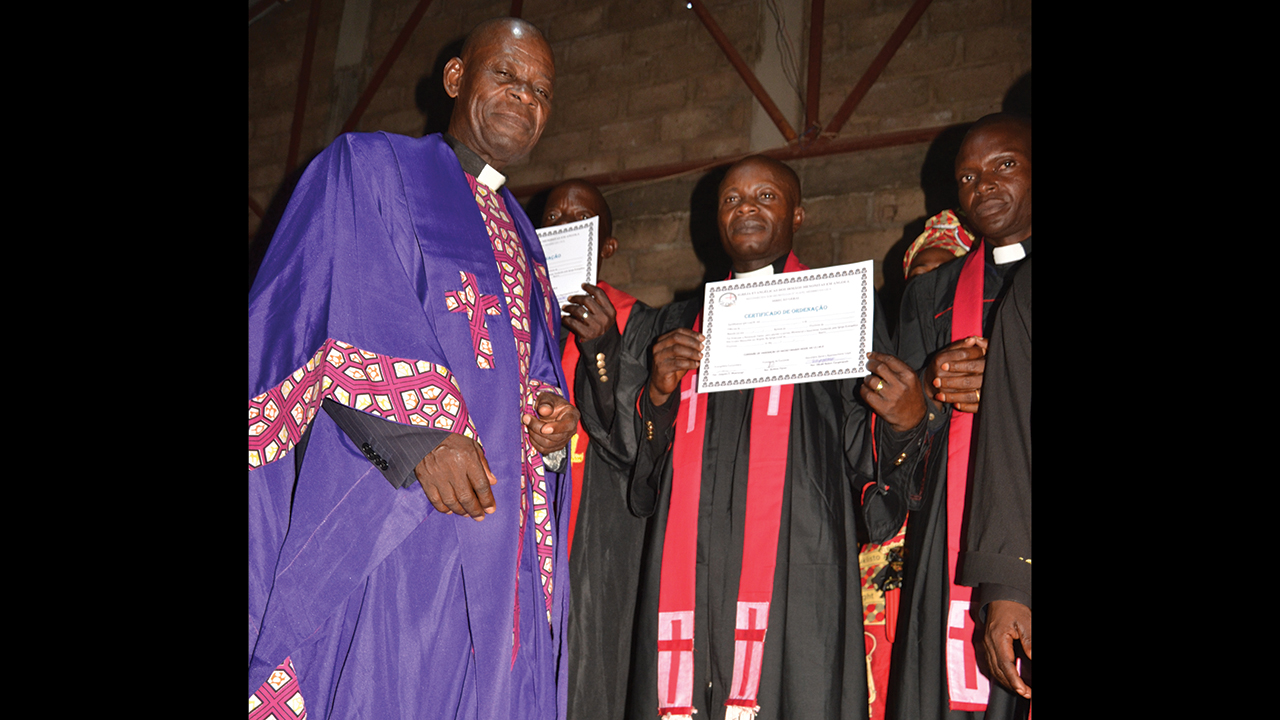 National ordination commission president Antônio Panzo, left, hands newly ordained pastor Andre Mukanishi his certificate in Cafunfo, Angola. — Mennonite World Conference
