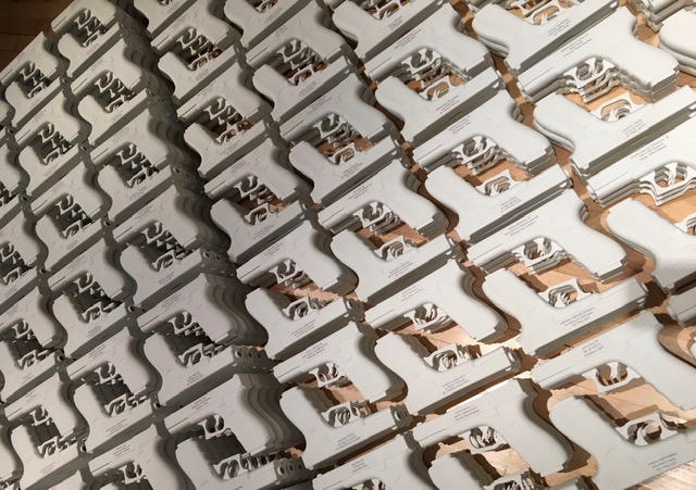 Art exhibit of white ceramic guns on a wall.