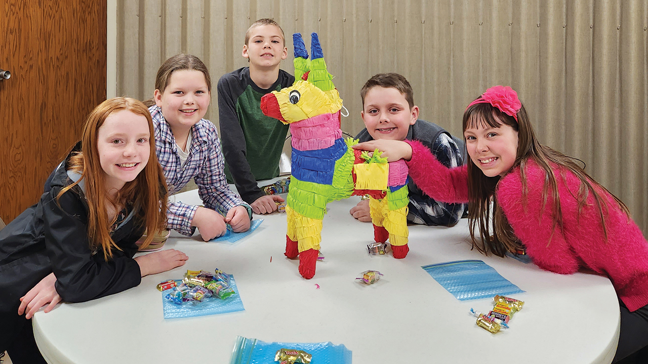 Eve Buller, Hannah Adrian, Stephan Nickel, Peter Graber and Lydia Nickel with the donkey piñata. — Carol Duerksen