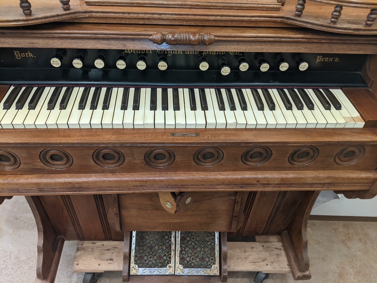 brown pump organ with white and black keys