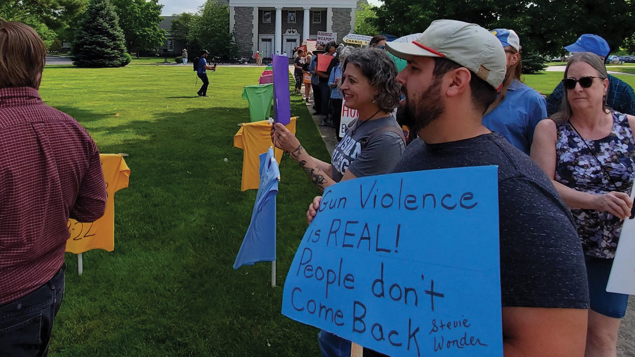 Salford Mennonite Church interim associate pastor Karen Bergey and associate pastor Andrew Zetts, center, and members of other local Mennonite churches walk May 21 near Trinity Lutheran Church in Lansdale, Pa., to honor people lost to gun violence and support stronger gun laws. — Joel Alderfer/Salford Mennonite Church