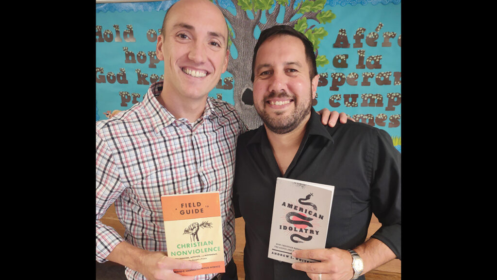 Andrew L. Whitehead, left, and David C. Cramer hold each other’s books: Cramer’s A Field Guide to Christian Nonviolence and Whitehead’s American Idolatry. — David Cramer