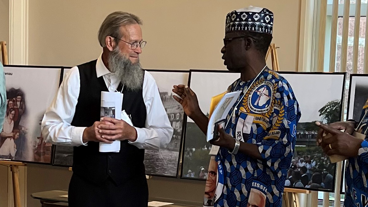 Joel S. Billi, right, president of Ekklesiyar Yan’uwa a Nigeria, chats with an Old German Baptist Brethren member from Indiana. — Steven Nolt/Young Center for Anabaptist and Pietist Studies