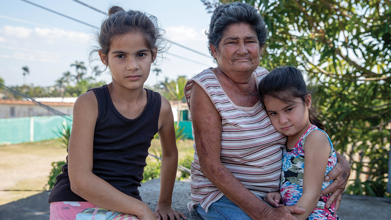 Caridad Rodríguez Gonzalez received an MCC relief kit through MCC partner Christian Center for Reflection and Dialogue after Hurricane Ian hit Cuba in 2022. She shares it with her grandchildren, Vanessa Gomez Cabrera, left, and Erica Gomez Cabrera, who live with her. — Annalee Giesbrecht/MCC