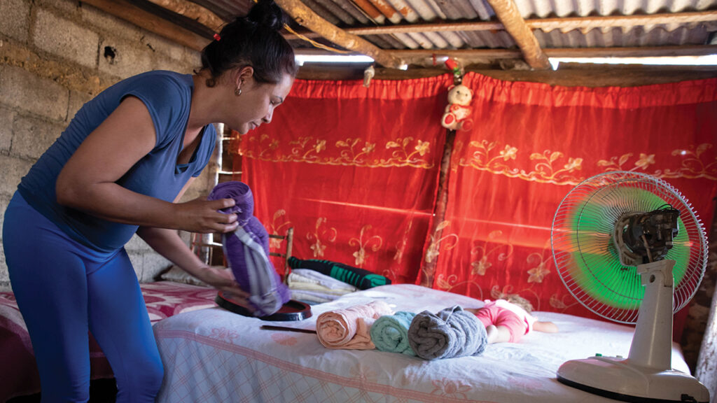 Ana Malena Cruz Montero unpacks items from an MCC relief kit in the small outbuilding on her property where her family is sleeping after Hurricane Ian damaged the roof of her house in 2022. She will receive material to repair the roof. — Annalee Giesbrecht/MCC