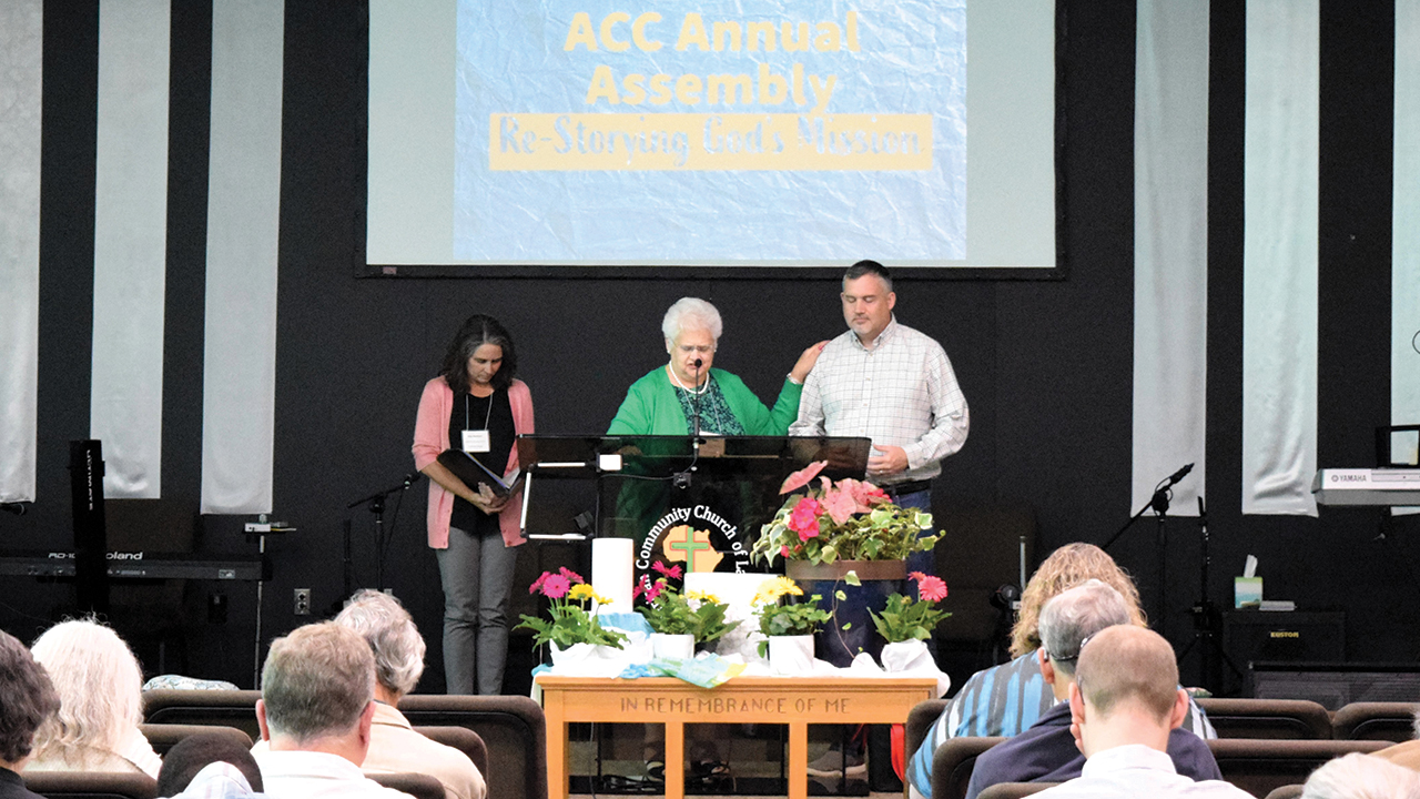 Joanne Dietzel, center, conference minister of Atlantic Coast Conference of Mennonite Church USA, prays with Kevin Kanagy, pastor of Hope Community Church of Fleetwood, Pa., at ACC’s annual assembly April 22. Delegates released Hope and Oley Valley Mennonite Church at their request. At left is Gina Burkhart, ACC moderator. — Atlantic Coast Conference