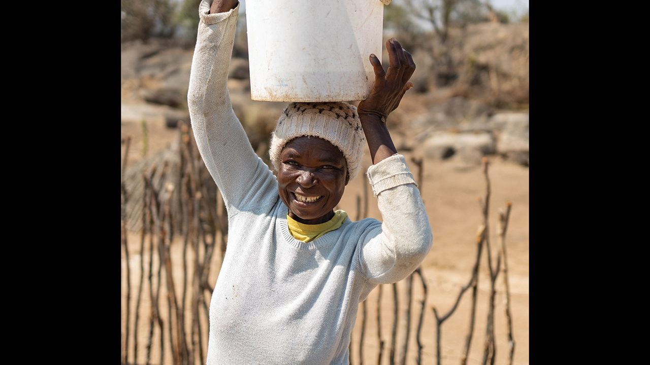 Rebecca Murereki holds an empty pail she uses to carry cow dung to her biodigester in Zimbabwe’s Mwenezi District. Murereki is part of a project that will be scaled up through new funding to empower women and develop clean energy solutions for climate change adaptation. — Meghan Mast/MCC