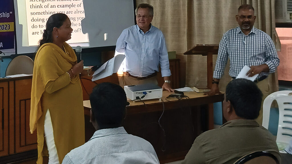 David Boshart and Vikal Pravin Rao look on while Sangita Tigga of Bihar Mennonite Mandli conference reports from a small group session. — Andi Santoso/MMN