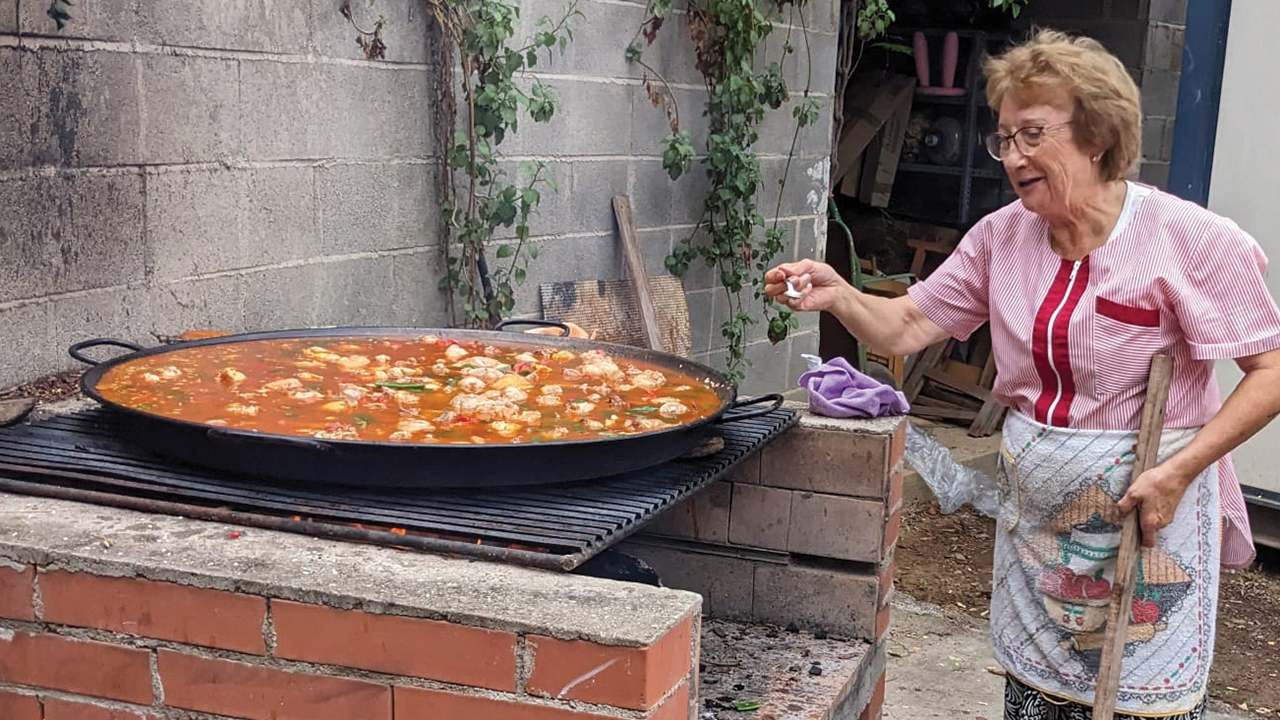 Dona Adelina of Comunidad Menonita de Barcelona cooks paella for European Leadership Mennonite Conference attendees. — José Arrais/MWC