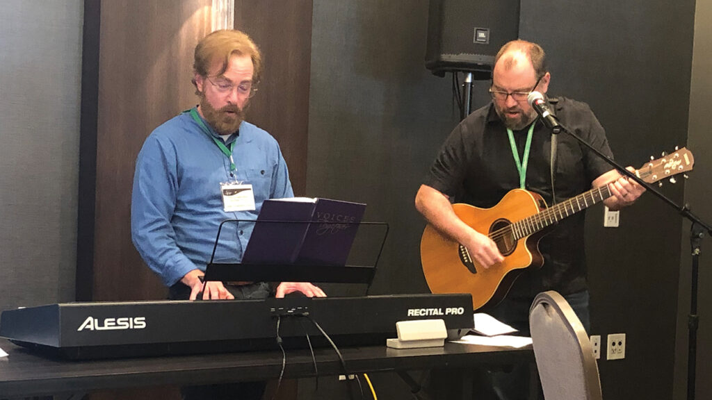 Randy Spaulding left, pastor of Boulder Mennonite Church in Colorado and the representative for the Queer Constituency Council of Mennonite Church USA, and Nathan Luitjens, executive conference minister for Central Plains Mennonite Conference, lead worship at the Constituency Leaders Council meeting in San Antonio, Texas, in March. — Erica Lea-Simka