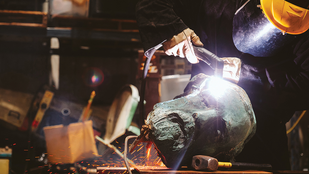 A foundry worker using a plasma torch prepares to cut the head of Charlottesville’s bronze monument of Robert E. Lee in preparation for melting the statue on Oct. 21. — Eze Amos