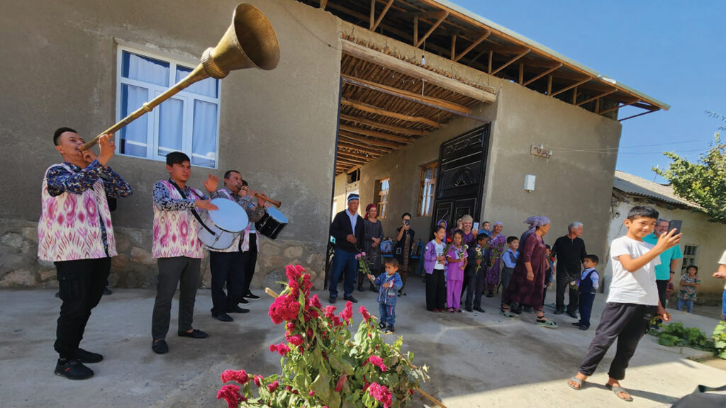 The Karimov family welcomes the tour group to their multigenerational family compound with brass, drums and bouquets. — Karen Sensenig