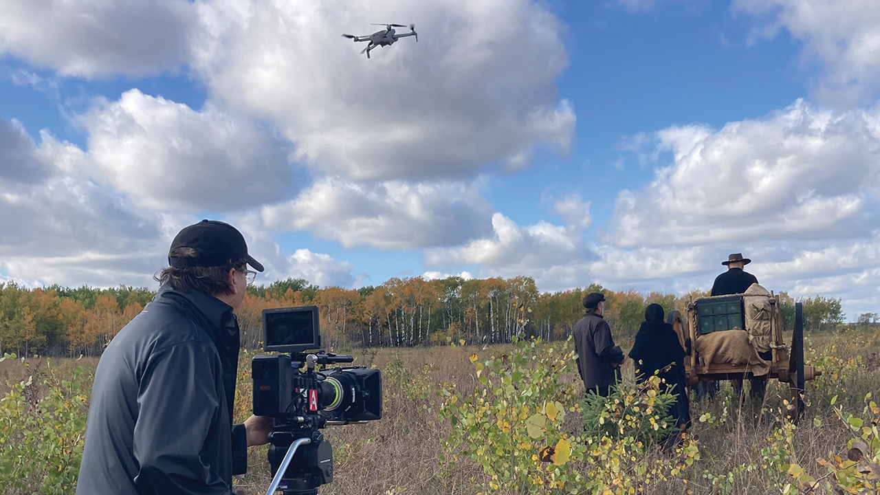 Dale Hildebrand, with camera and a drone, shoots a Red River (Métis) ox cart scene. — Dale Hildebrand
