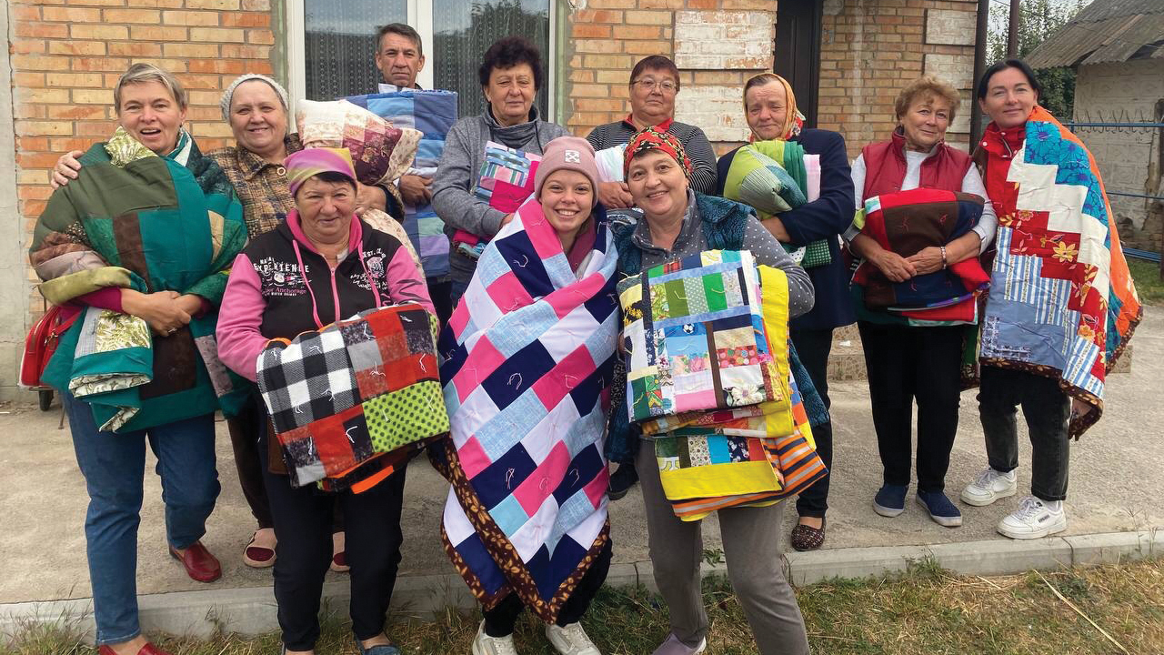 Recipients display MCC comforters they received when the Association of Mennonite Brethren Churches of Ukraine distributed relief items in the Zaporizhzhia region in October. — AMBCU