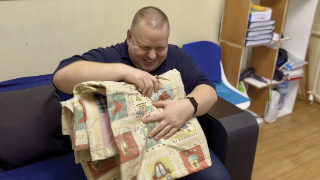Serhiy of Nikopol, Ukraine, holds the comforter he received through an MCC partner. — New Life Charitable Fund