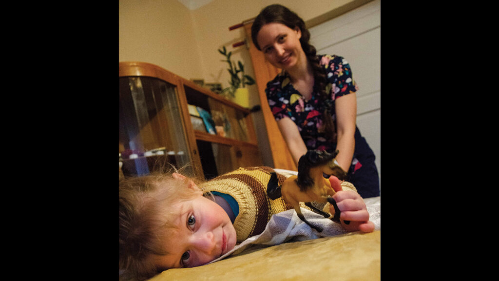 Margaryta* uses massage techniques on Milana during therapy for children who are displaced and affected by war. — Association of Mennonite Brethren Churches of Ukraine *The last names of the adult and child are not provided for security reasons.