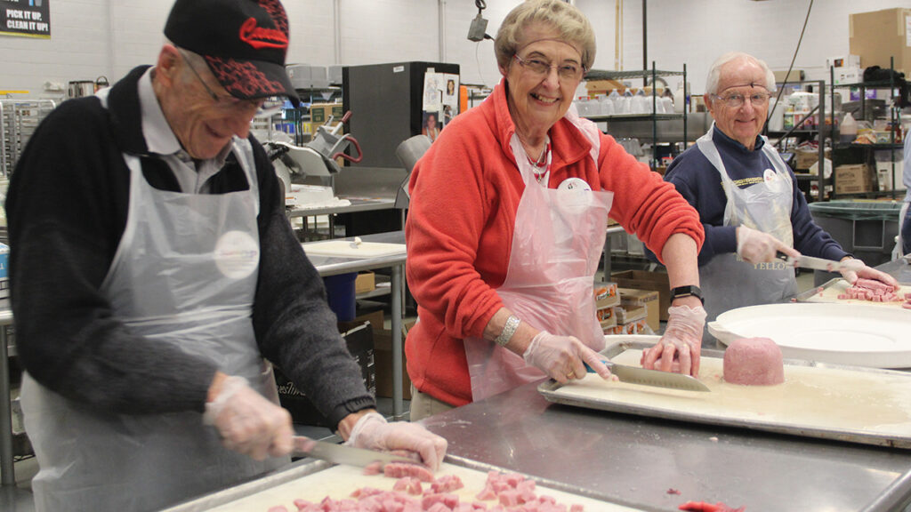 2018 SOOP Phoenix participants, from left, Bruno Friesen, Leanne Gross and Roland Yoder prepare food at the Society of St. Vincent De Paul Food Reclamation Center in Phoenix. The Phoenix SOOP location began in 1993, originally in the home of Peter and Rheta Mae Wiebe. It now operates out of the Menno Guest House, which houses SOOP volunteers during the winter and serves as a bed and breakfast throughout the rest of the year. — Travis Duerksen/MMN
