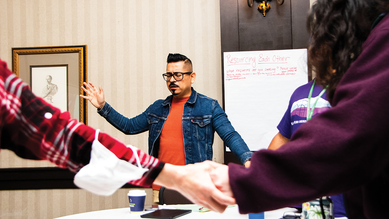 Sergio Nava, Iglesia Menonita Hispana (Hispanic Mennonite Church) Executive Board member, prays with attendees. — Juan Moya/AW