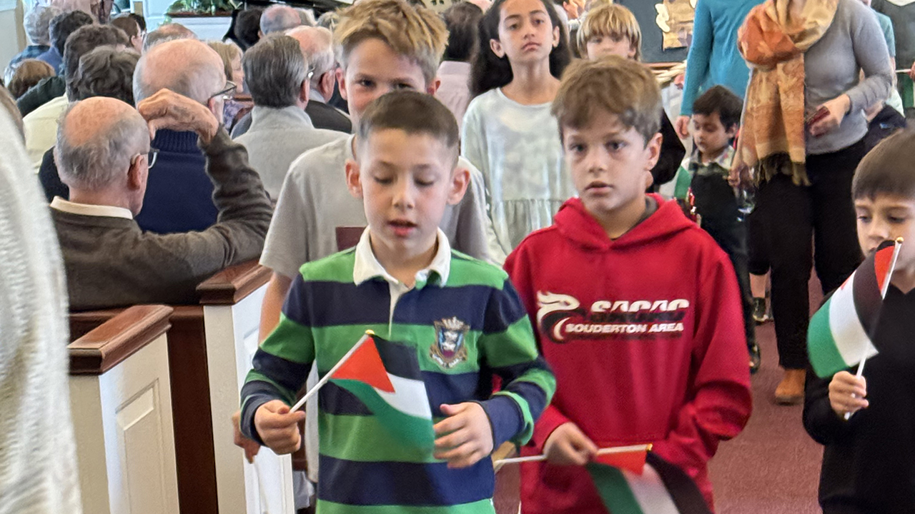 Children receive Palestinian flags after Aisha Yasin read a story during children’s time. — Randy Martin/Jeremi Tumanan