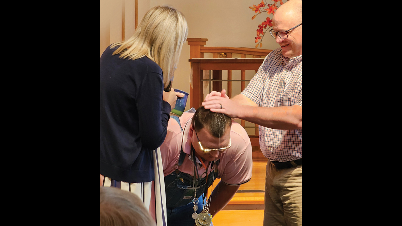 Amanda Swartley and Derek Yoder baptize Robert Silvers at Lindale Mennonite Church. — Megan Sandberg
