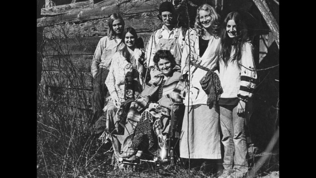 Eleanor Smith, seated, with her Koinonia household in 1973, posing by a broken-down shed in the style of the time. —Courtesy of Eleanor Smith