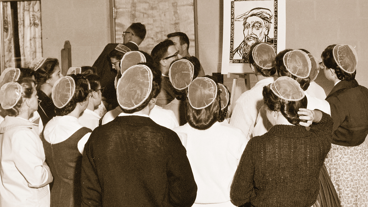 In 1961, Eastern Mennonite College faculty and students view a portrait of Menno Simons by alumnus Warren Rohrer in the Menno Simons Historical Library. Women’s head coverings were gradually shrinking, but cut and flowing hair was not permitted. Sweaters were an acceptable substitute for cape dresses. — Eastern Mennonite University Archives