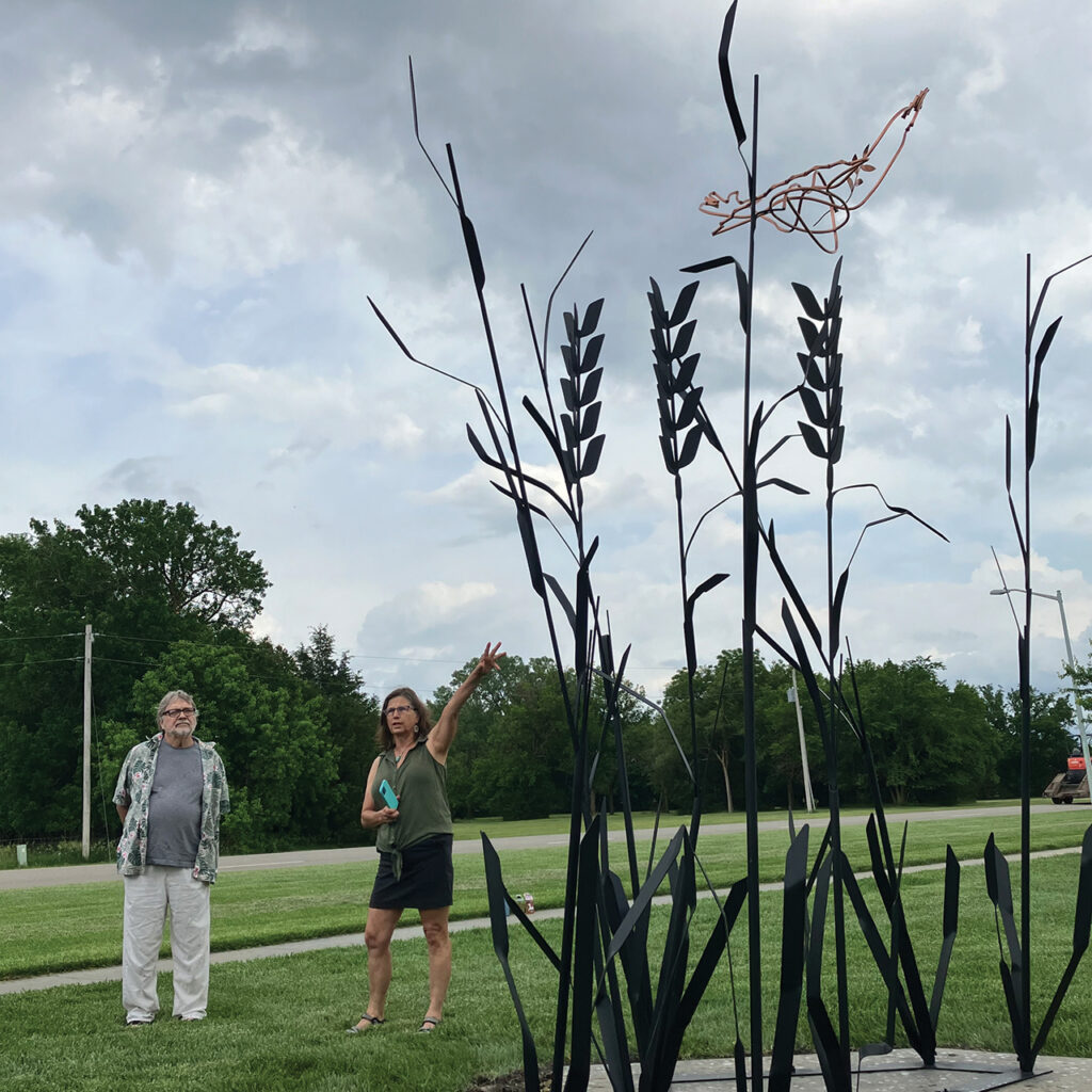 Ann Zerger, with fellow sculptor Chip Parker, speaks at the dedication of “Fields of Hope,” a sculpture commemorating the heritage of Russian Mennonite immigrants and the region’s Indigenous people, on May 31 in Moundridge, Kan. — Paul Schrag/AW