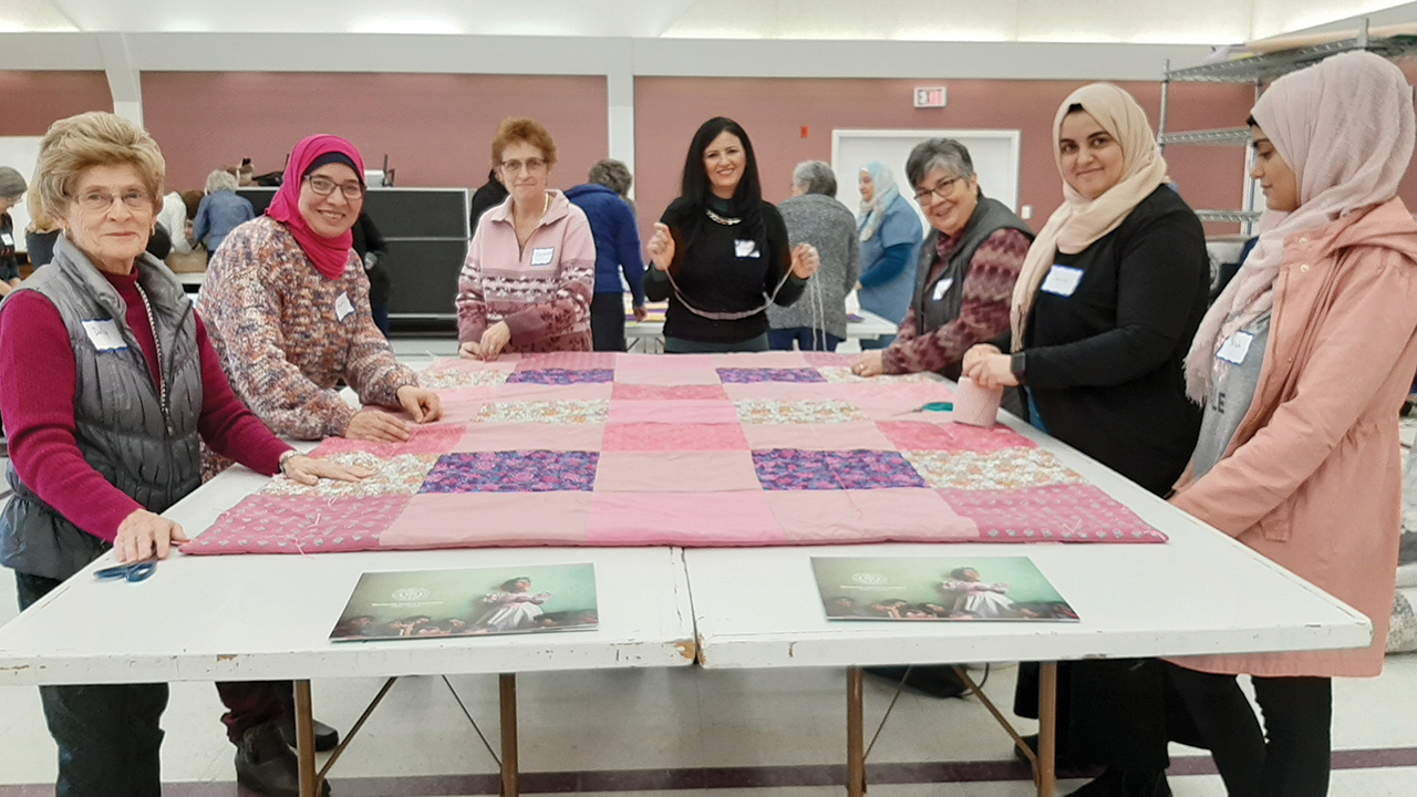 Muslim and Mennonite quilters in Edmonton work together during the Great Winter Warm Up for Mennonite Central Committee in 2020. — Suzanne Gross