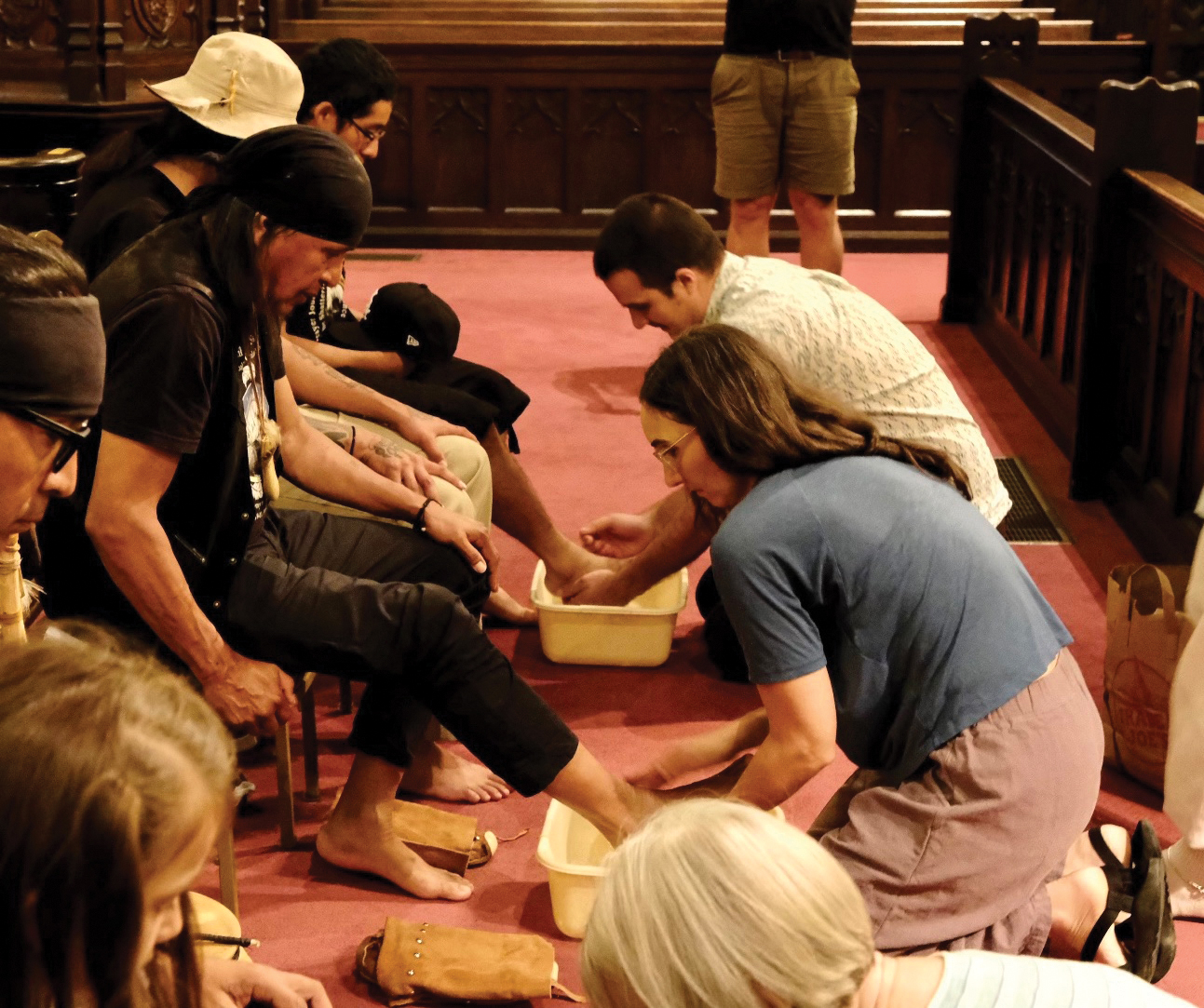 Melissa Florer-Bixler, pastor of Raleigh Mennonite Church and Benjamin Rudeen Kreider, pastor of Chapel Hill Mennonite Church, wash the feet of Dr. Wendsler Nosie and other members of Apache Stronghold Sept. 4 at Church of the Good Shepherd in Raleigh, N.C. — Steve Pavey