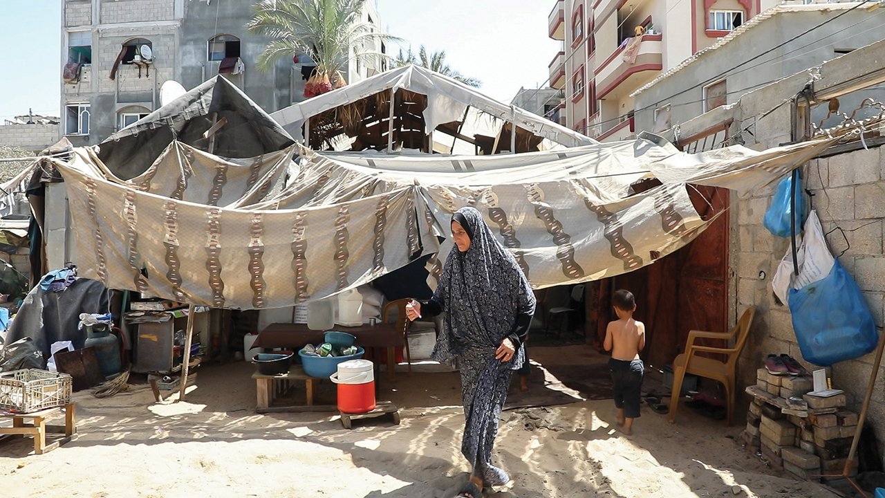 Andaleeb Abu Al Qumbuz walks outside her family’s temporary dwelling where they are living since being displaced four times by the Israeli military’s invasion of Gaza. — Mahmoud Meqdad