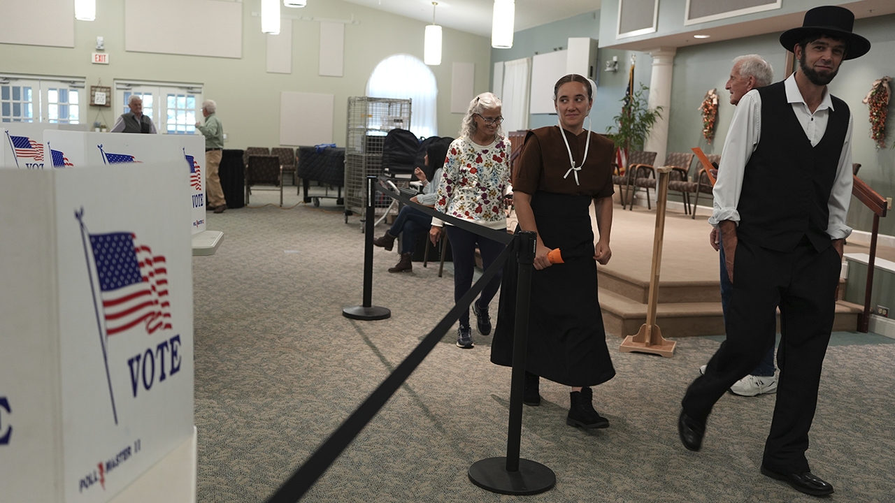 Lillian Stoltzfus and her husband, Samuel Stoltzfus, walk out of a polling center Nov. 5 after voting at Garden Spot Village in New Holland, Pa. — Luis Andres Henao/Associated Press