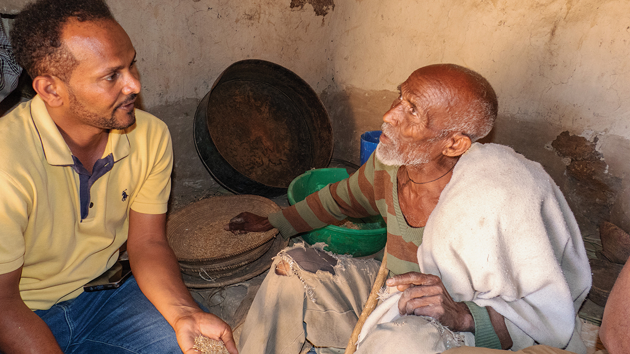 Bizuayehu Abera speaks with Gash Tareka Gebreyesus, a beneficiary of cash transfers from the Meserete Kristos Church Development Commission. — Paul Mosley/MCC