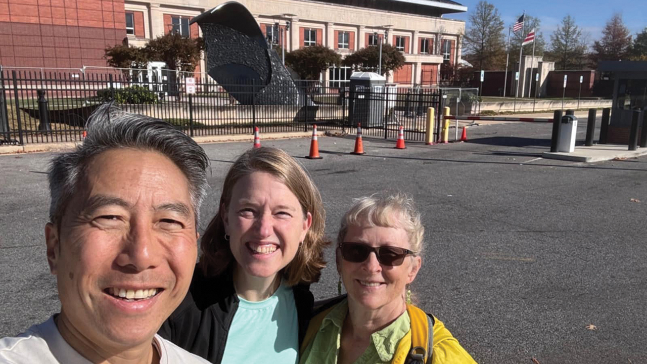 Pastor Andrew Cheung, Angie Chou and Martha E. Byers of Washington Community Fellowship in front of "Guns Into Plowshares" during their Election Day visit to the sculpture. — Courtesy of Andrew Cheung