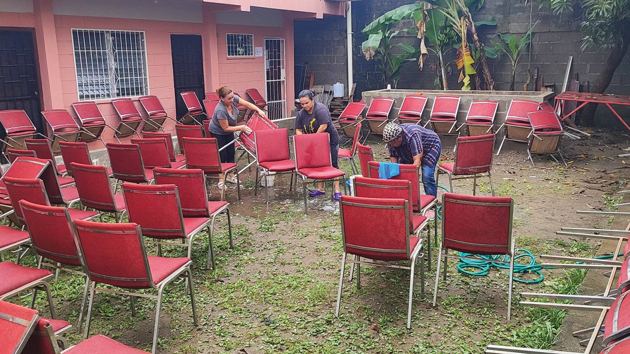 Members Carmen Herrera, Mirian Howell and Juana Reyez of Iglesia Evangélica Menonita Central de La Ceiba in Honduras wash and dry chairs after multiple feet of water flooded the sanctuary in November. — Iglesia Evangélica Menonita Central de La Ceiba