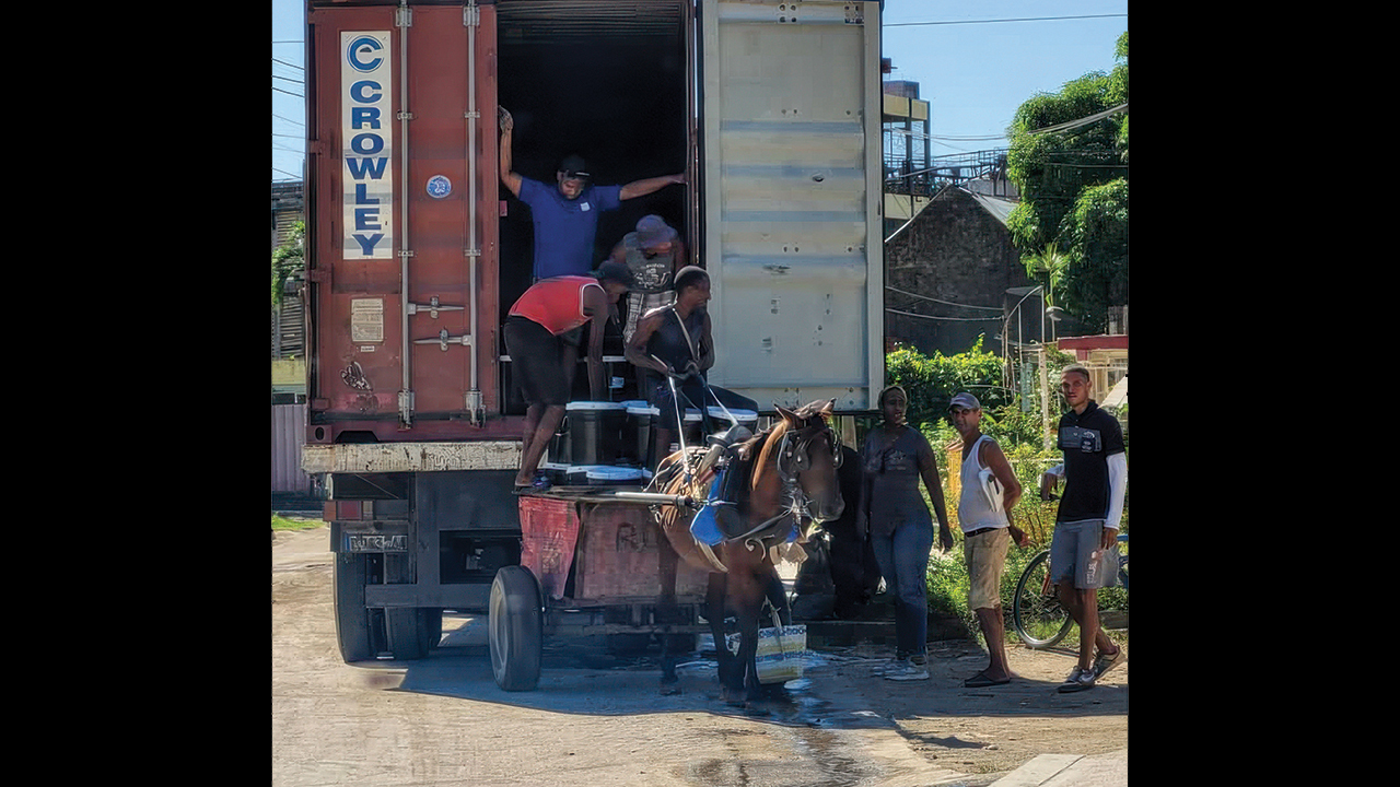 Workers transfer the contents of an MCC shipping container to local transportation in Santiago de Cuba. — BIC Church of Cuba