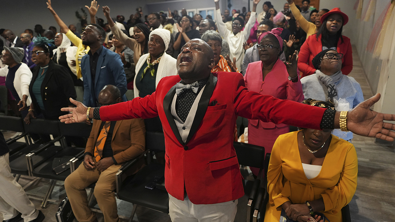 Jean-Michel Gisnel prays with other congregants at First Evangelical Haitian Church of Springfield, Ohio, Jan. 26. — Luis Andres Henao/AP
