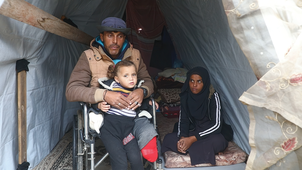 Ahmed and his wife and daughter sit inside the shelter set up for them by workers from MCC’s partner, Al-Najd Developmental Forum. — Al-Najd