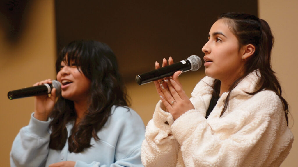 Krissia Contreras, left, and Lorena Slashchev of Manantial de Vida (Fountain of Life), a Mennonite con­gre­ga­tion in Harrisonburg, Va., sing during the “Singing Our Faith” celebration. — Dale D. Gehman