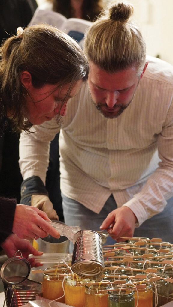 Participants pour melted wax into jars to make new candles as gifts to each congregation and committee of the Swiss Mennonite Conference. — Swiss Mennonite Conference