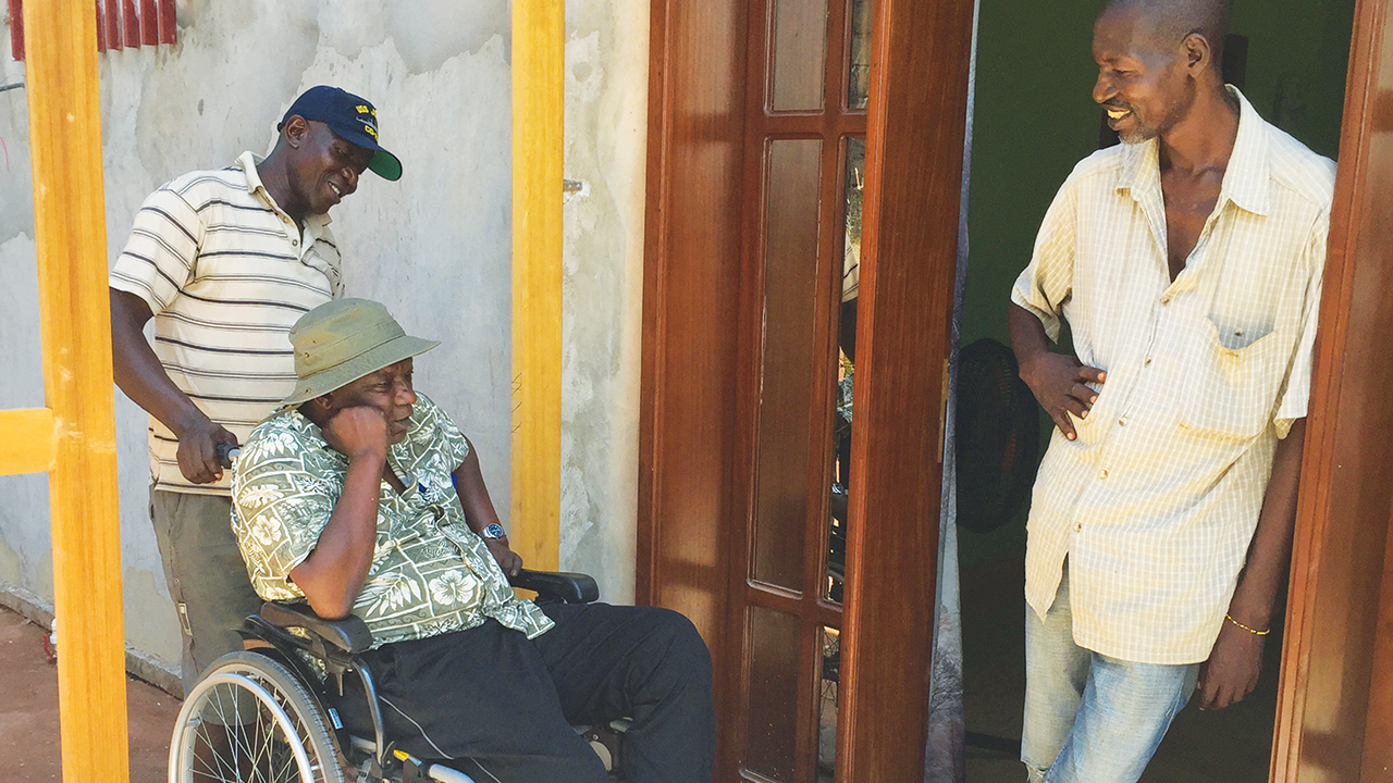 Pakisa K. Tshimika in Kinshasa, Democratic Republic of Congo, with brother Sammy, right, and caregiver/driver Keji Emile. — Photo courtesy of Pakisa K. Tshimika