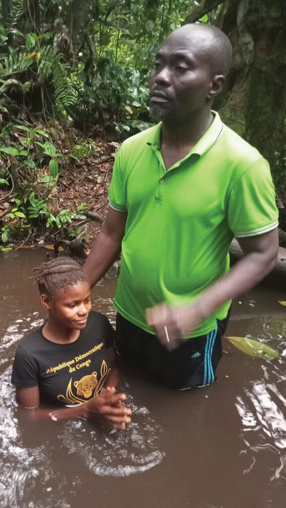 Nathan Mudiji baptizes a Batwa girl. At this event, 229 people were baptized. — Mennonite World Conference