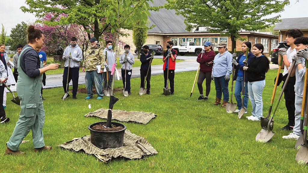 Staff and volunteers of Faith in Place, an interfaith environmental justice organization led by Mennonite pastor Brian Sauder, plant a tree in Waukegan, Ill. — Faith in Place