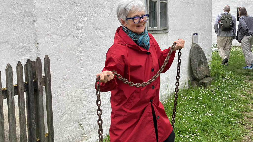Tour participant Shirley Hershey Showalter holds a chain at the Niedersulz museum in Austria that symbolizes Anabaptist women who were chained to their houses. — Paul Schrag/AW
