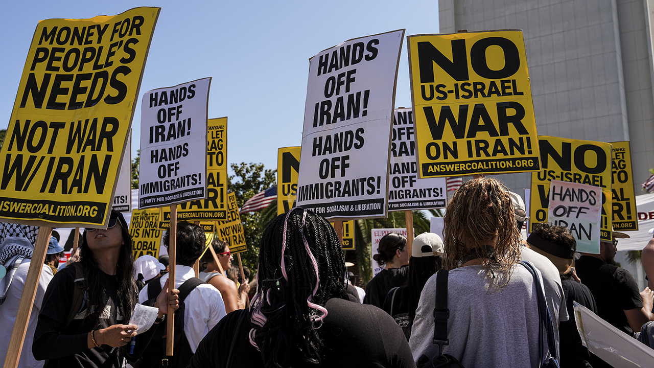 Antiwar demonstrators hold signs outside the Wilshire Federal Building in Los Angeles on June 22 after U.S. airstrikes on Iran's nuclear facilities. — Jae C. Hong/AP