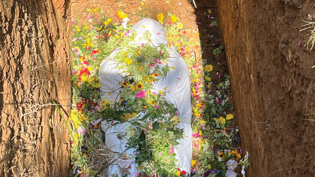 Flowers, grass and dirt on top of Frank Albrecht’s body. — Courtesy of Elizabeth Soto Albrecht