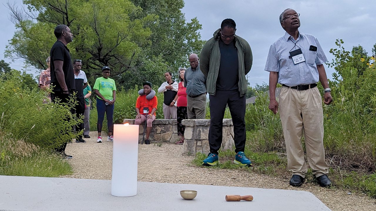 Members of the Brethren in Christ Church of Zimbabwe diaspora pray and sing after lighting a candle July 5 at Dyck Arboretum of the Plains in Hesston, Kan. — Tim Huber/AW