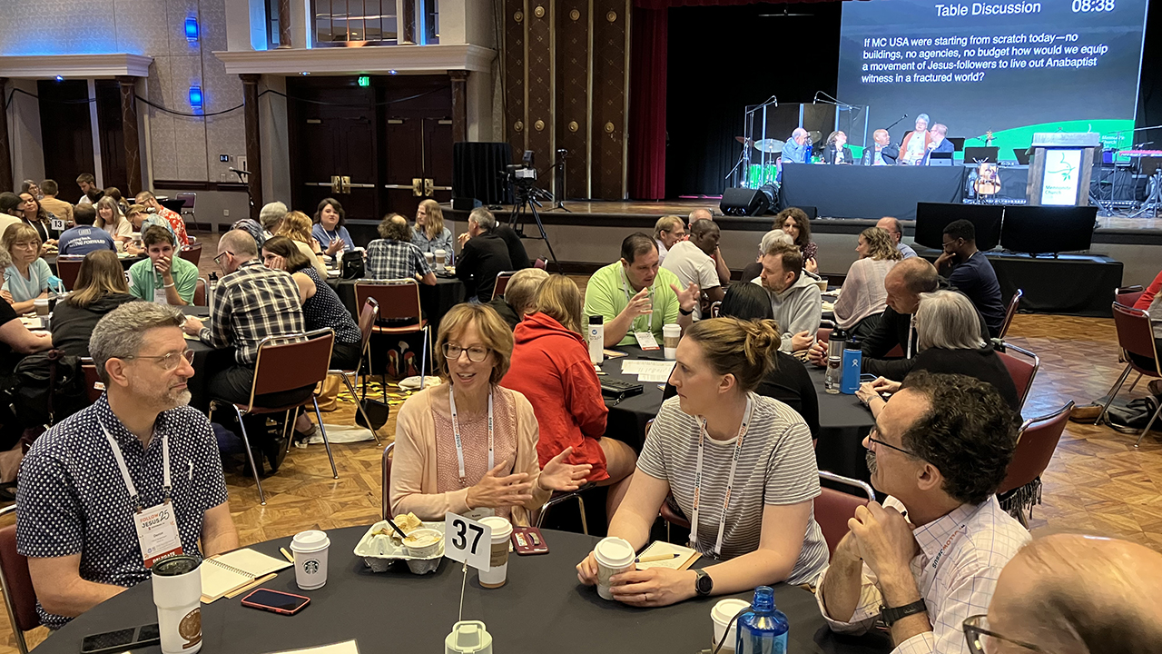 People talk at tables during the Mennonite Church USA Delegate Assembly on July 11 in Greensboro, N.C. — Paul Schrag/AW
