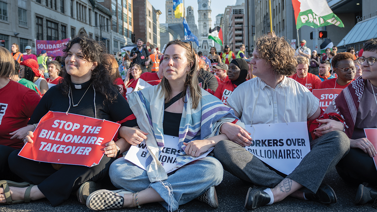 Jay Bergen, right, pastor of Germantown Mennonite Church in Philadelphia; Rabbi Lizzie Horne Mozes, center; and Rev. Hannah Capaldi participate in an action linking immigration and worker justice on May 1 in Philadelphia. — Juan Ramos